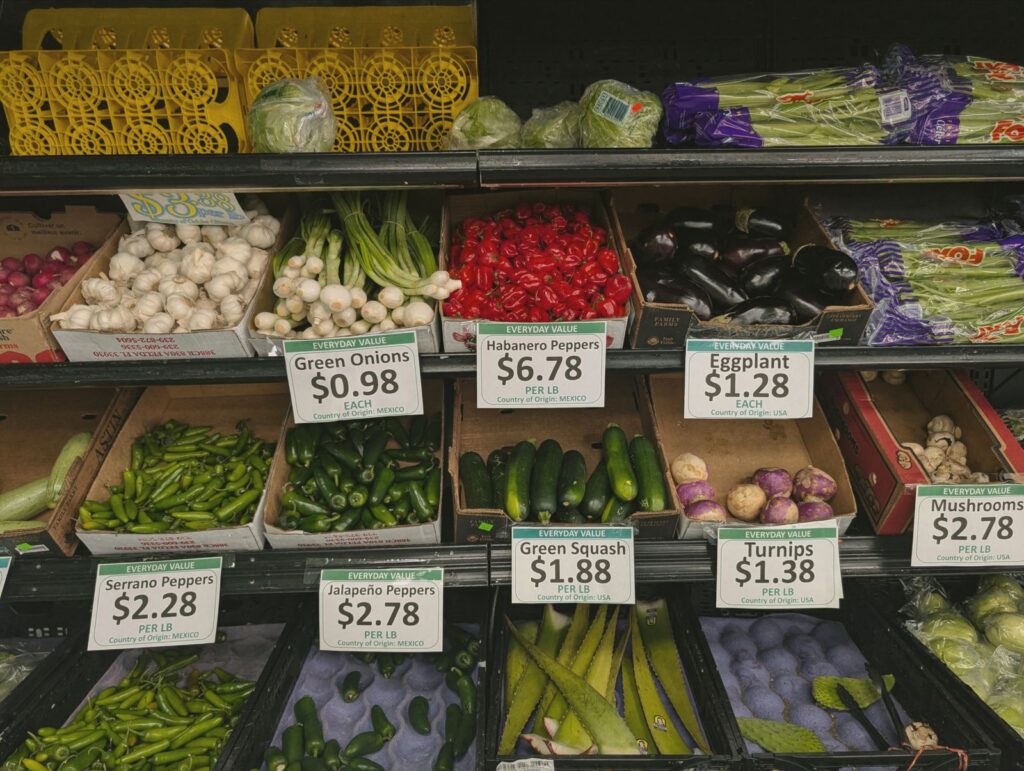 Vegetables on market shelves with handwritten price tags